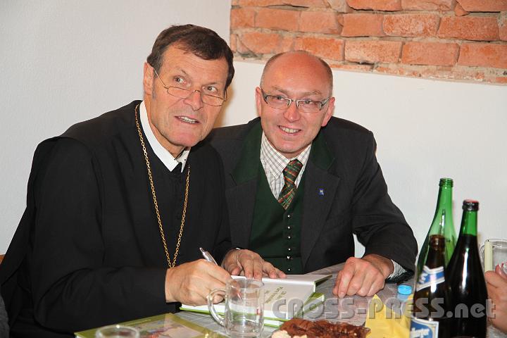 2012.10.13_21.58.34.jpg - Abt Berthold signiert das Buch über die Geschichte der Pfarre für Bürgermeister Franz Kirchweger.