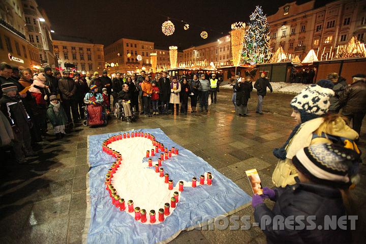 2010.12.04_18.01.48.jpg - Am Hauptplatz gegenber dem Adventmarkt formten die Teilnehmer, darunter viele Kinder, mit ihren Kerzen einen Embryo.