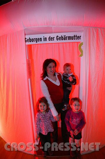 2009.01.11_16.23.14.JPG - Vor dem Eingang ins "Gebrmutterzelt": Andrea Pichler, Mutter zweier kleiner Kinder, gestaltete Ausstellungsfolder und Logo.