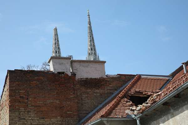 Potres / Erdbeben / Earthquake in Zagreb, Croatia Ein Loch im Dach mit gebrochener Glockenturmspitze im Hintergrund.