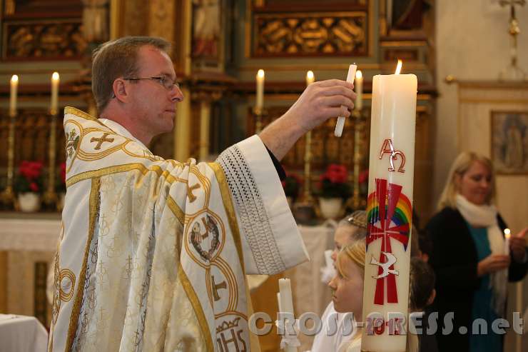 2015.05.14_09.27.43.JPG - Pfarrer P.Georg Haumer zündet die Erstkommunionskerzen an der Osterkerze an.