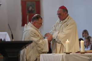 FriedensFest zu Ehren von Dr. Stefan Matzenberger Pfarrer Biela bindet Bischof Schwarz ein Friedensarmband an sein Handgelenk.